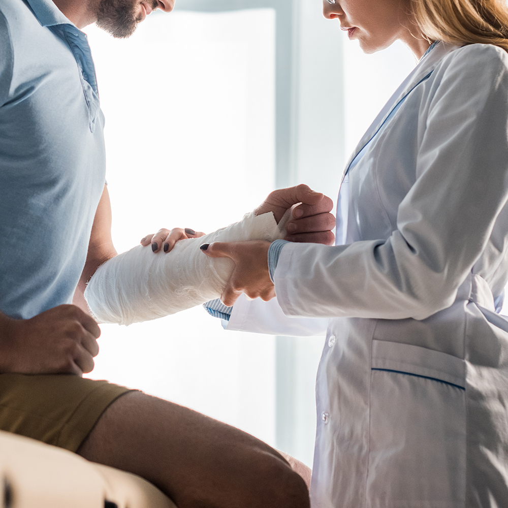 Clinician examining a patient’s arm in a cast